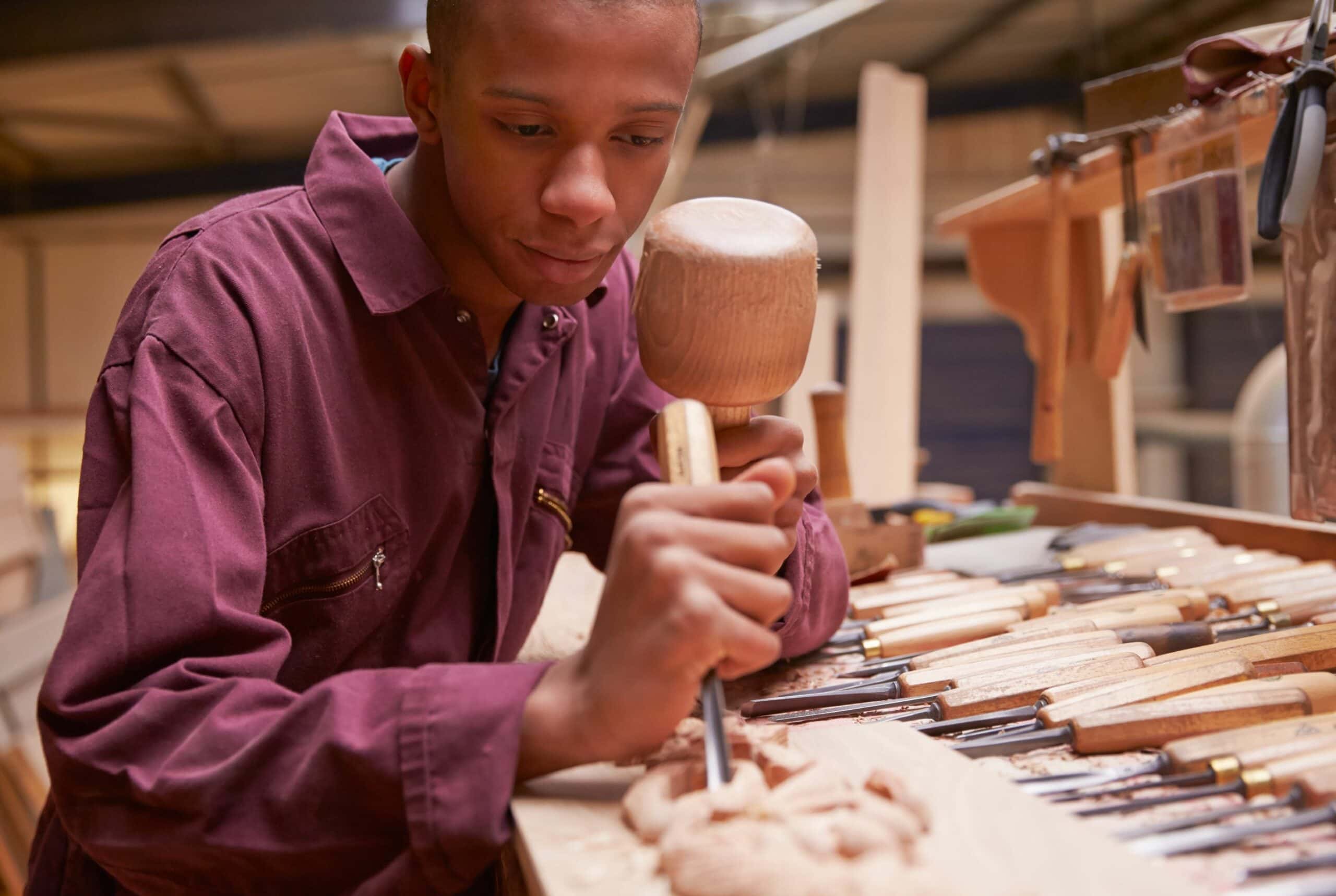 Man Carve Wood In Workshop